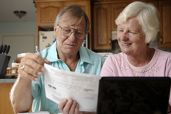 An elderly couple sorting out their bills.