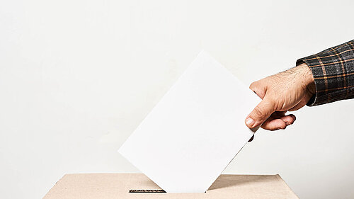 Person throwing a ballot in a box