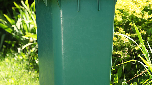A wheelie bin overflowing with rubbish.
